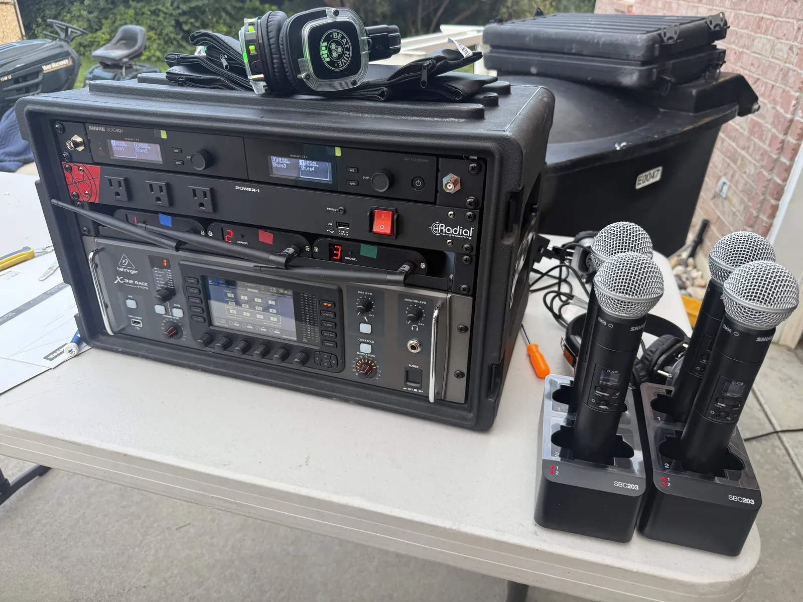 Wireless microphone rack with four handheld transmitters set up for a conference
