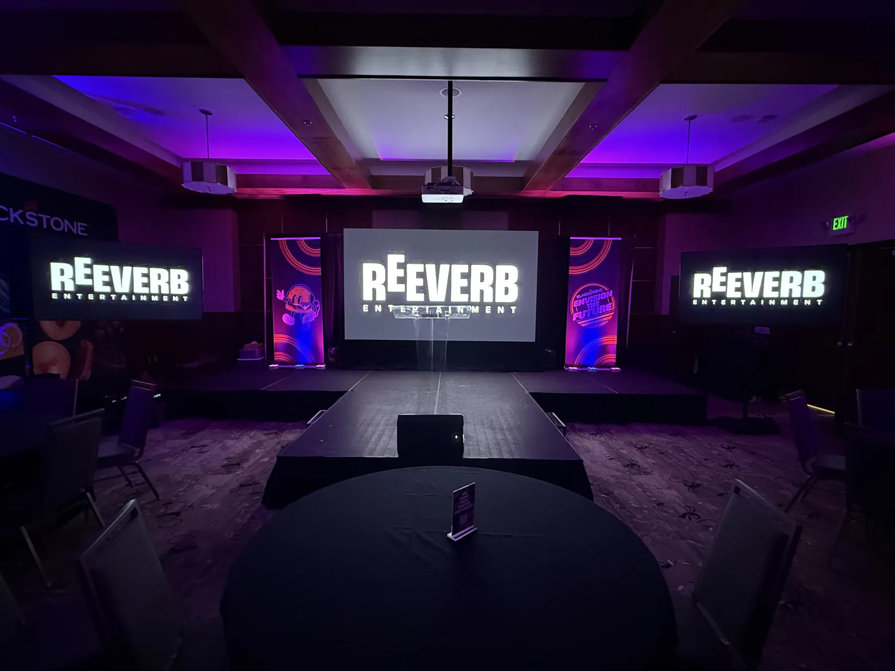 Stage rental with a three screen video wall, pipe and drape, and a lectern set for a corporate general session