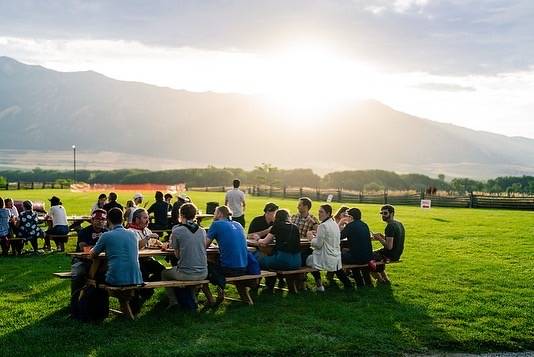 Golden hour dinner on a lawn with mountain views
